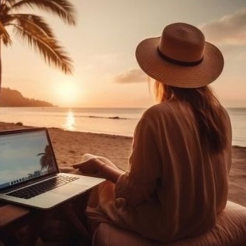 Marina Flores trabajando con su portátil en una playa al atardecer